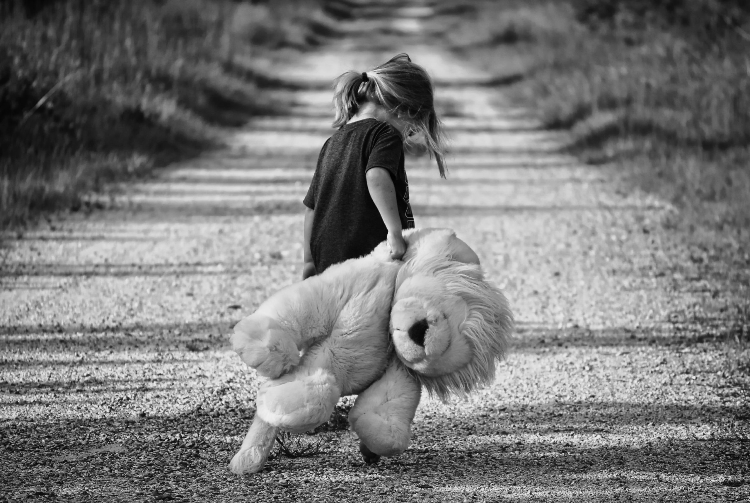 Small girl dragging teddy bear